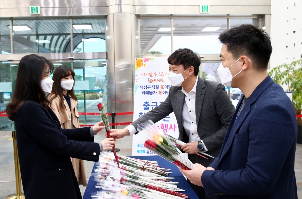 13일 오전 유성구청 로비에서 조남석 유성구공무원노동조합 위원장이 출근하는 직원들에게 장미꽃을 전달하고 있다.