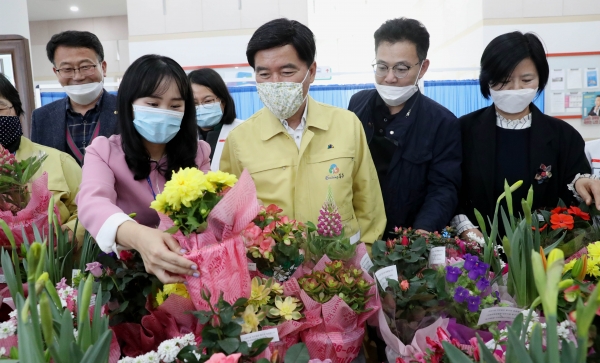 황인호 동구청장이 기탁 받은 화분을 들여다보고 있다.