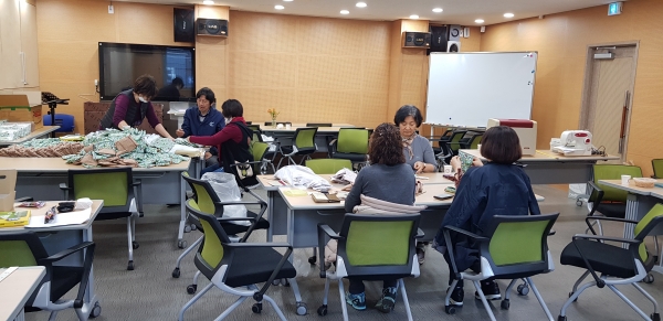 지난 25일 진잠동 행정복지센터에서 주민자치회 위원들이 면마스크를 위생적으로 관리하고 보관할 수 있는 마스크보관지갑을 제작하고 있다