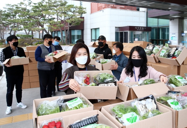 26일 구청 현관 앞에서 유성구 공무원들이 일만 원 상당의 지역농산물꾸러미를 구매하고 있다.