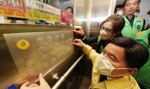 황인호 동구청장이 30일 판암동 삼정그린코아 아파트를 방문해 지역자율방재단원과 함께 엘리베이터 버튼에 코로나19 항균필름을 부착하고 있다