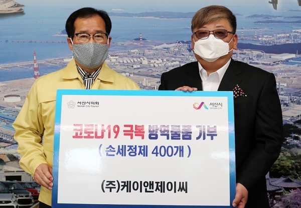 ㈜케이앤제이씨 윤정현(오른쪽) 대표가 방역물품 기부했다.