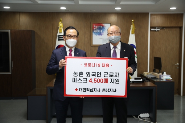 지난 20일 대한적십자사 충남지사가 농업분야 외국인 근로자를 위한 마스크 4500매를 천안시에 기증해 박상돈 시장(왼쪽)과 유창기 회장(오른쪽)이 기념사진을 촬영하고 있다.