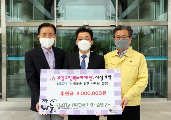 22일 구청 본관 입구에서 ㈜한국조경기술연구소 김동일 대표(가운데)가 정용래 유성구청장(오른쪽)과 신동천 유성구행복누리재단 상임이사(왼쪽)에게 코로나19 극복을 위한 후원금 400만 원을 기탁하고 있다