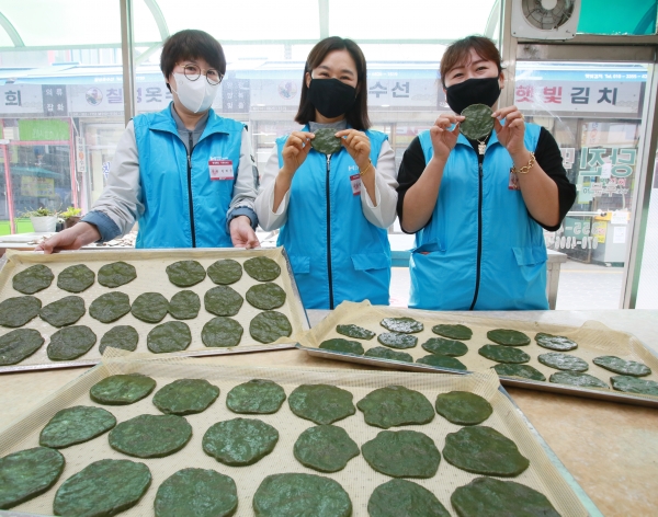 현대제철 당진제철소 마중물 주부봉사단이 직접 만든 쑥개떡을 들어 보이고 있다.