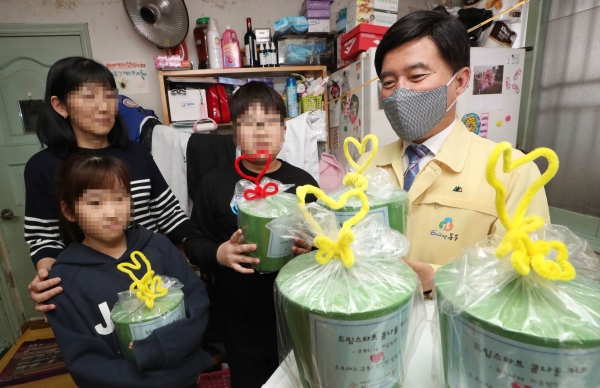 황인호 동구청장이 드림스타트 지원 대상 가구를 방문해 콩나물 키트를 살펴보고 있다.