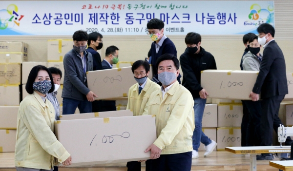 황인호 동구청장과 이나영 동구의회 의장이 중앙시장 이벤트홀에서 소상공인이 제작한 면 마스크를 나르고 있다