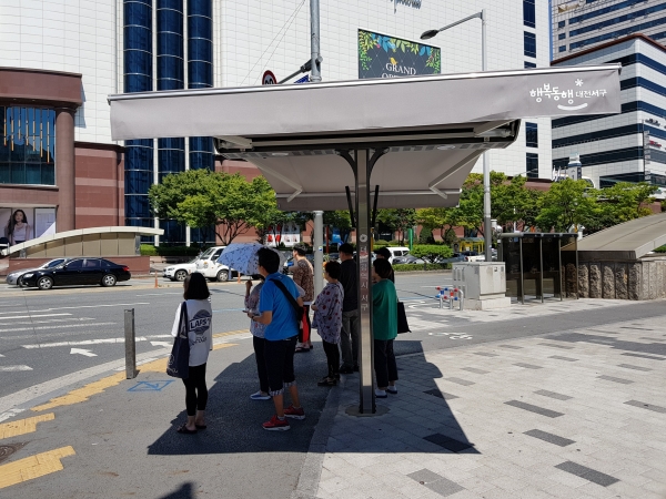 지난 9월 갤러리아타임월드 인근에 대전 최초로 설치된 스마트그늘막에서 시민들이 무더위를 식히고 있다