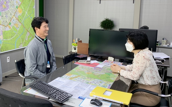 민원인이 공인중개사에게 상담을 받고 있다.