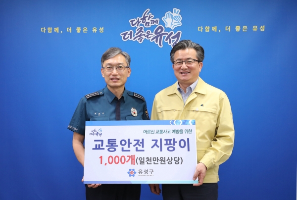 12일 구청 행복사랑방에서 육종명 유성경찰서장(왼쪽)이 유성구로부터 어르신 교통사고 예방을 위한 교통안전지팡이 1,000개를 전달받고 정용래 유성구청장(오른쪽)과 함께 기념촬영