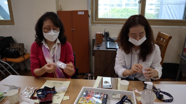 지난 12일 유성구 자원봉사센터에서 시민정원사 봉사팀이 지역 주민들에게 나눠줄 목걸이형 손소독제를 조립하고 있다.