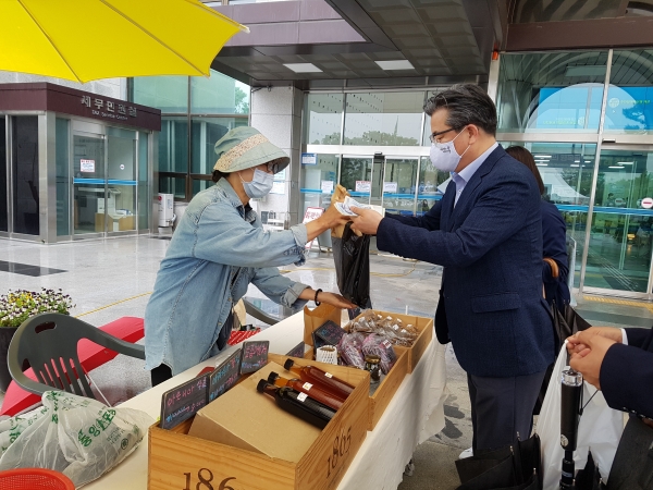 지난 15일 유성구청 광장에서 열린 ‘만원의 행복팜(farm)꾸러미’ 직거래장터에서 정용래 유성구청장이 지역농산물 꾸러미를 구매하고 있다