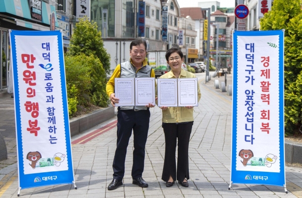 18일 송촌동상점가에서 김서환 송촌동상가번영회장(왼쪽)과 박정현 대덕구청장(오른쪽)이 ‘대덕e로움과 함께하는 만원의 행복’운영 업무협약 맺고 기념촬영