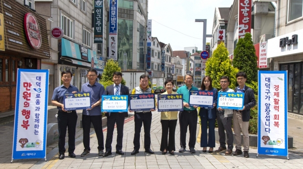 18일 송촌동상점가에서 김서환 송촌동상가번영회장(왼쪽)과 박정현 대덕구청장(오른쪽)이 ‘대덕e로움과 함께하는 만원의 행복’운영 업무협약 맺고 기념촬영