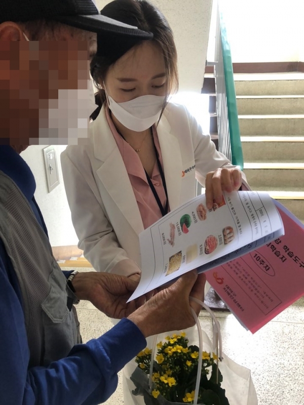 치매어르신 가정에 ‘행복 기억보따리’를 전달하며 상담하는 모습