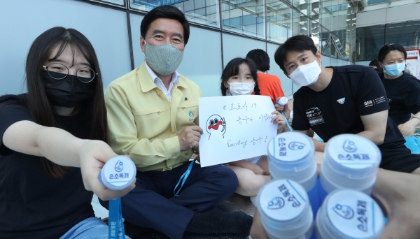 황인호 동구청장과 자원봉사자들이 목걸이형 손소독제를 들어보이고 있다.