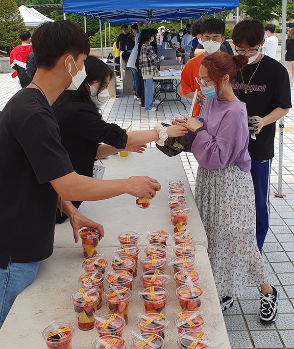 목원대 총동아리연합회 임원들이 학생들에게 컵 과일을 나눠주고 있다.