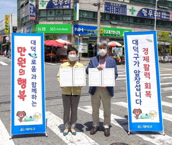 27일 비래동 상점가에서 박정현 대덕구청장(왼쪽)과 김대승 비래동상가번영회장(오른쪽)이 ‘대덕e로움과 함께하는 만원의 행복’운영 업무협약 맺고 기념촬영
