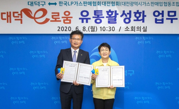 8일 구청에서 박종환 한국LP가스판매협회 대전협회장(왼쪽)과 박정현 대덕구청장(오른쪽)이 지역화폐 대덕e로움 유통활성화 업무협약 맺고 기념촬영