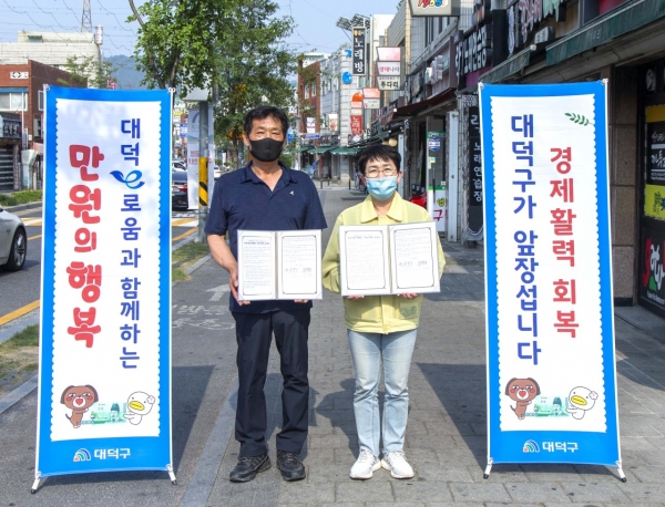 지난 9일 중리행복길에서 이익근 중리행복길상가번영회장(왼쪽)과 박정현 대덕구청장(오른쪽)이 ‘대덕e로움과 함께하는 만원의 행복’ 운영 업무협약 맺고 기념촬영