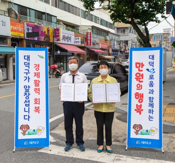 17일 신탄진새시장상가거리에서 박정현 대덕구청장(오른쪽)과 김광식 신탄진새시장상가번영회장(왼쪽)이 만원의 행복 업무협약 체결 모습