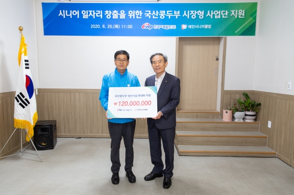 김병숙 사장(오른쪽)이 태안시니어클럽 조혁 관장에게 기금을 전달하고 기념 촬영을 하고 있다.