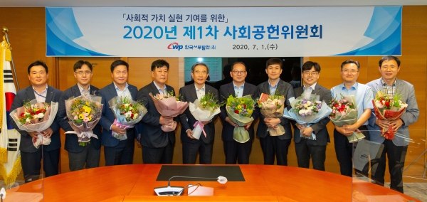 서부발전 김병숙 사장(왼쪽 5번째)과 사내‧외 위원들이 태안지역 생산 화훼를 들고 사회공헌위원회 개최 기념촬영을 하고 있다.