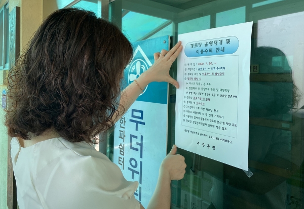 부춘동 경로당 담당직원이 운영재개 안내표를 경로당에 부착하고 있다