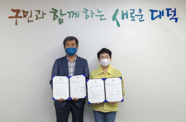 22일 구청에서 허형욱 법1동구역주택재건축 정비사업조합장(왼쪽)과 박정현 대덕구청장(오른쪽)이 업무협약을 맺고 기념촬영