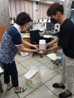 종이팩을 가지고 행정복지센터를 방문한 시민이 화장지를 교환받고 있다.