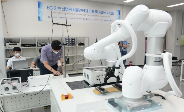 ETRI 연구진이 스마트공장 내 이동형 로봇을 국산 5G 기술을 이용해 실시간으로 제어하는 모습.