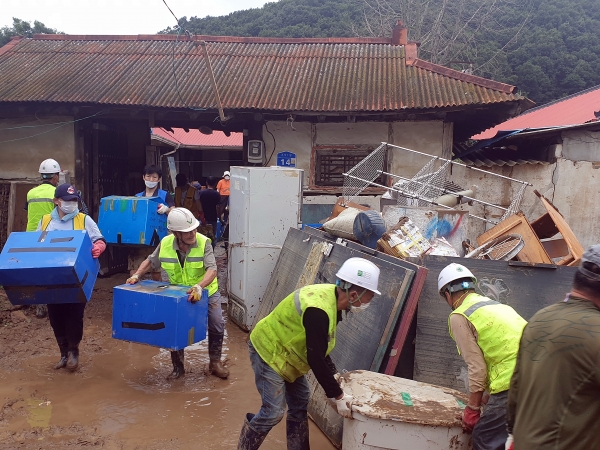 에스엘홀딩스 구성원들이 지난 6일 집중호우로 침수피해를 입은 천안시 동남구 목천면 소사리 마을일원에서 침수피해 주택을 찾아 토사제거와 가구정리 등 복구지원을 하고 있다.