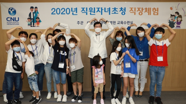12일 세종충남대학교병원이 마련한 2020년 직원 자녀초청 직장체험 프로그램에서 나용길 원장(사진 가운데)과 참여 가족들이 기념촬영을 하는 모습.
