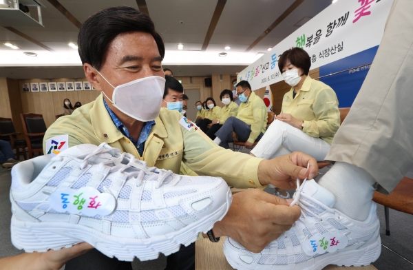 황인호 동구청장이 동장들에게 직접 동행화를 신겨주고 있다.