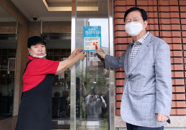 장종태 서구청장이 “제1호 안심식당”으로 지정된 음식점에 표지판을 부착하고 있다.