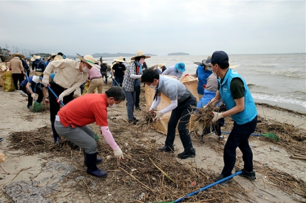 노박래 군수와 문성혁 장관이 해안가 쓰레기를 수거하고 있다