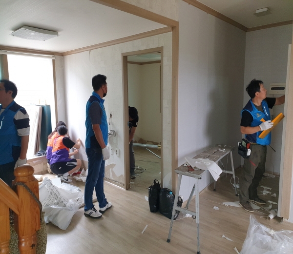 아산비젼과 온양중앙로타리 회원들이 지난 15일 온양3동 침수피해 가정에서 도배장판 시공을 하고 있다.