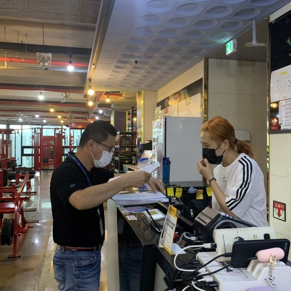 시 관계자가 고위험 실내집단운동 시설에 집합금지 조치사항을 전달하고 있다