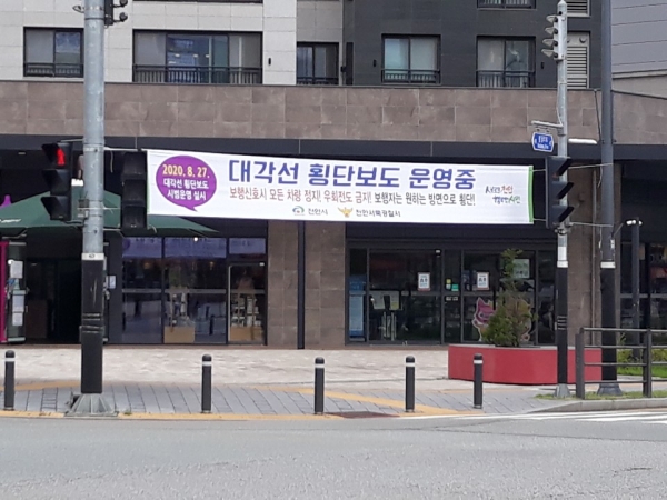 대각선 횡단보도 일원에 걸린 대각선 횡단보도 홍보 현수막