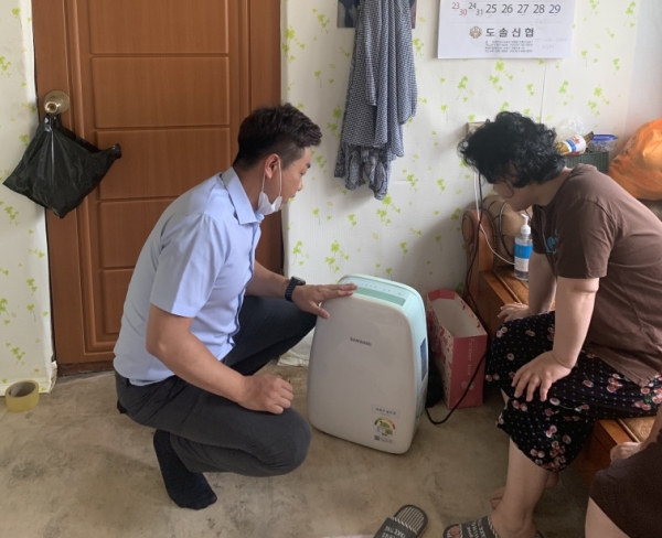 침수 피해 가구에 제습기 사용법 설명하는 김철환(왼쪽) 천안시의원.