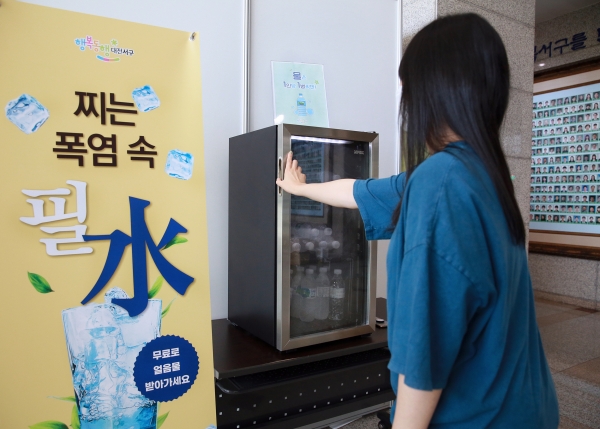 서구청을 방문한 주민이 1층 로비에서 설치된 냉장고에서 얼음물을 꺼내고 있다.