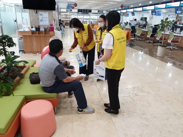 예산군에서 군청을 방문한 민원인에게 도로명 주소 홍보 마스크 목걸이를 배부하는 모습