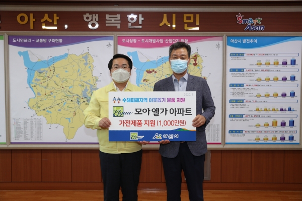 오세현 아산시장과 모아엘가그룹 한승훈 이사(오른쪽)가 후원물품 전달 후 기념사진