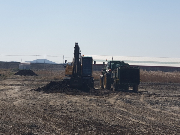 농지에 퇴비를 살포하고 있다.