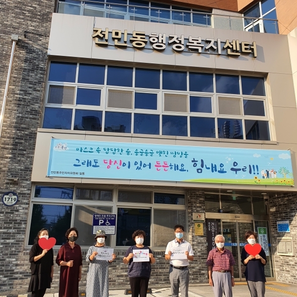 지난 8일 전민동 주민자치위원회 위원들이 ‘그래도 당신이 있어 든든해요. 힘내요 우리’라는 문구가 새겨진 현수막을 행정복지센터 입구에 게시하고 기념촬영