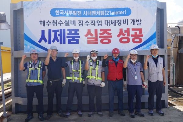 서부발전 사내벤처 2호팀이 9월 4일 평택발전본부에서 해수취수설비 수중작업 대체장비를 실증하고 파이팅을 외치고 있다