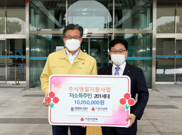 16일 구청 현관 입구에서 박용훈 사무처장(오른쪽)이 추석 명절을 맞아 저소득 가정을 위한 지원금을 전달하고 정용래 유성구청장(왼쪽)과 기념촬영