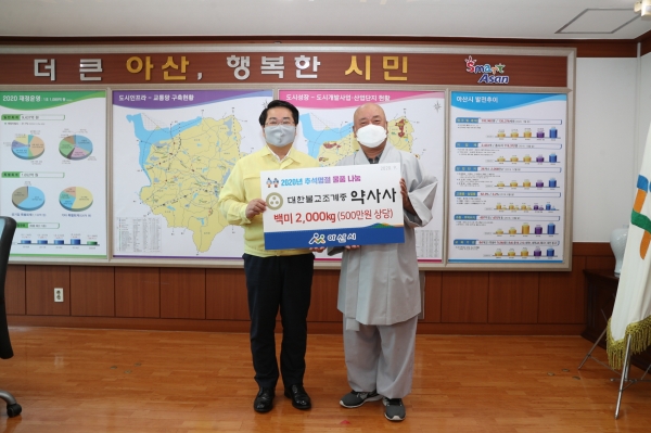 오세현 아산시장과 원묵 주지가 후원물품 전달 후 기념사진을 찍고 있다.