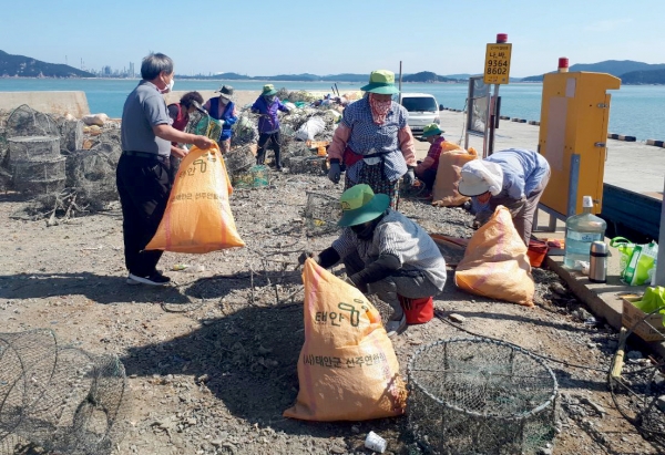이원면 만대항에서 폐통발의 그물 분리 작업을 하는 모습.