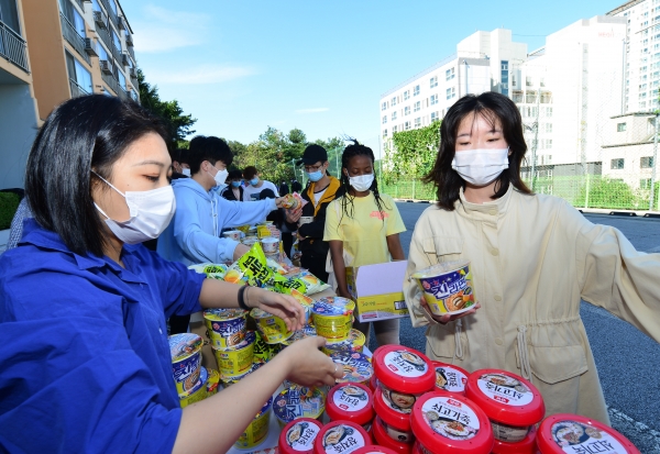 양 대학 국제교류처에서 준비한 식료품들을 유학생이 전달받고 있다.